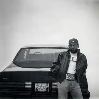 Kendrick Lamar stands next to a car for the release of his new album GNX