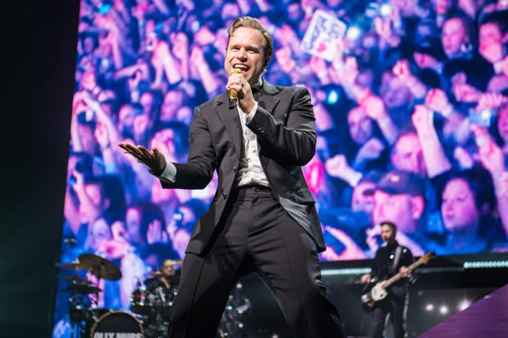 Olly Murs stands on stage at Leeds Direct Arena in front of screaming fans