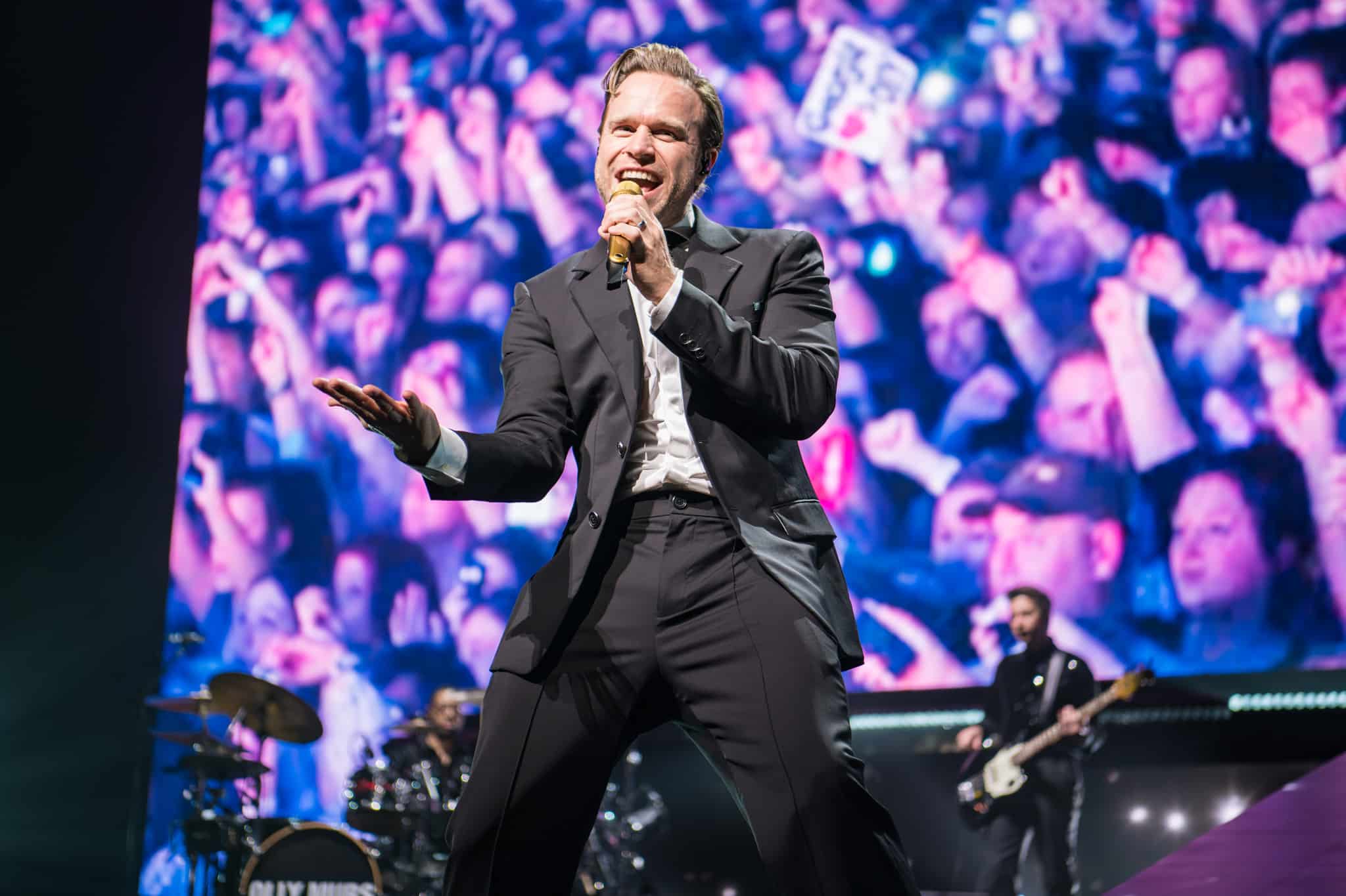 Olly Murs stands on stage at Leeds Direct Arena in front of screaming fans