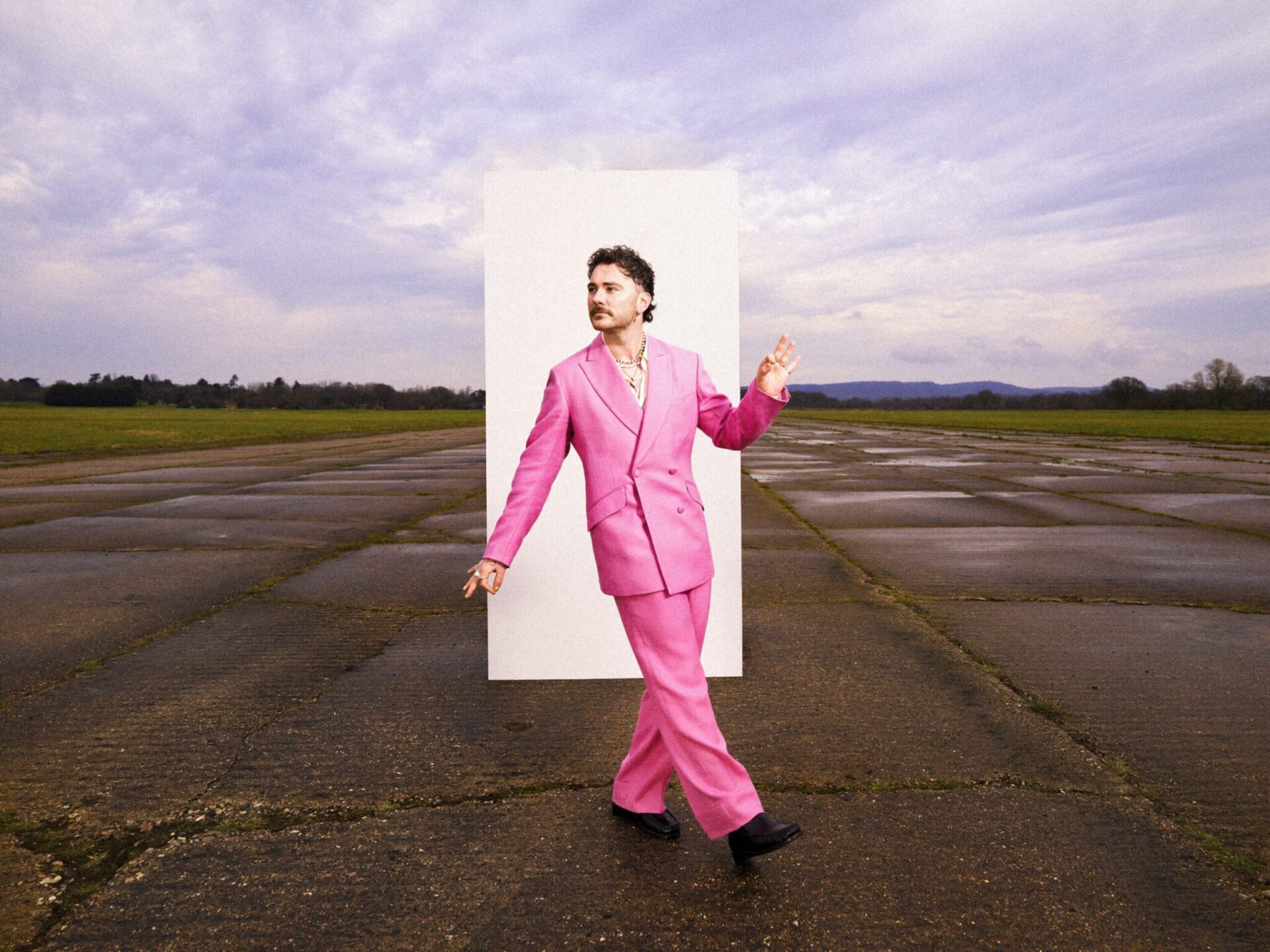Cian Ducrot stands in front of a large white rectangle on a barren patch of concrete