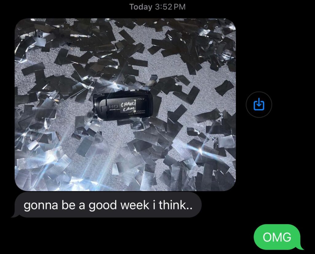 Camcorder labelled “Charli Cam” lying in silver confetti, teased in a text message from Charli XCX.