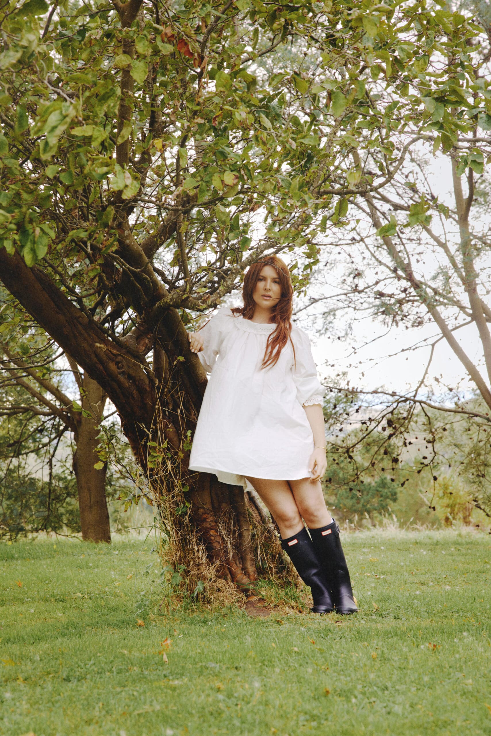 Georgia Lines stands leaning against a tree