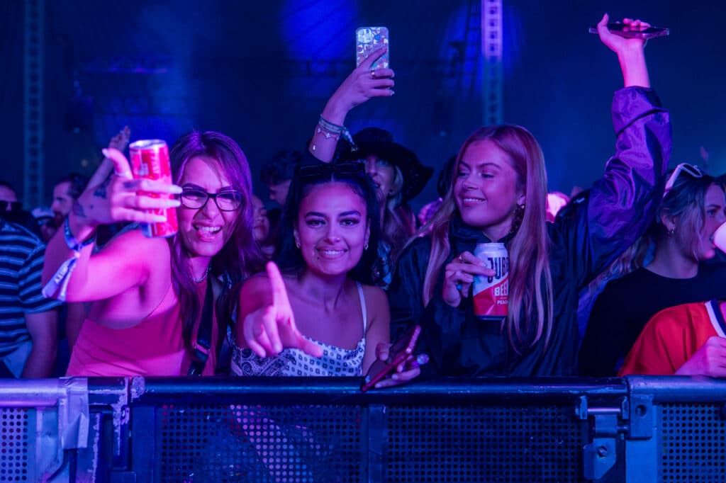 Girls stand at the barrier of LIDO Festival having fun