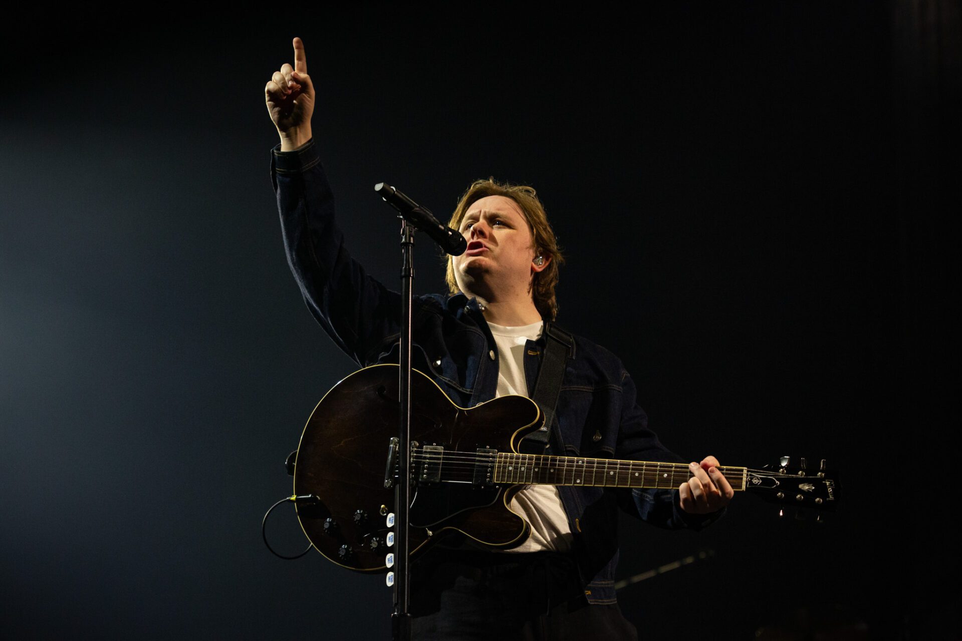 Lewis Capaldi performs on stage in Auckland surrounded by glowing phone lights during his emotional final song.
