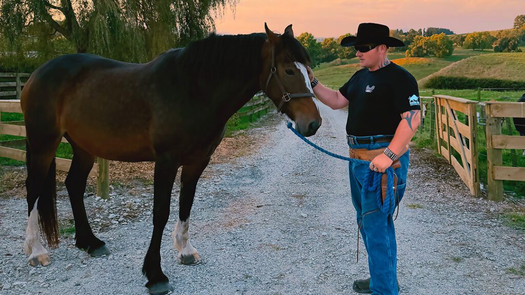 Trigger Happy standing stroking a horse