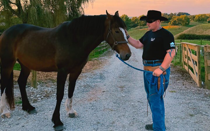 Trigger Happy standing stroking a horse
