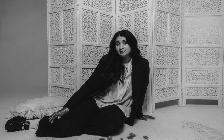 Sabreen sits on the floor in a black and white image