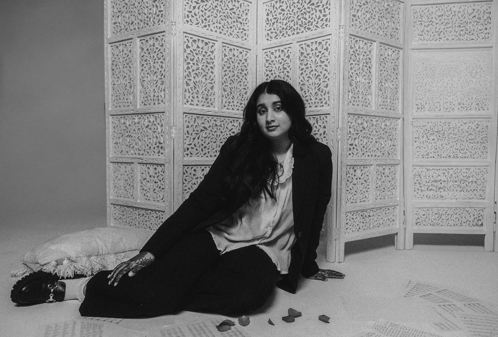 Sabreen sits on the floor in a black and white image